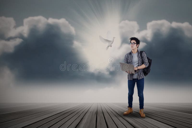 Estudante masculino que olha a pomba do voo imagens de stock Estudante masculino que olha a pomba do voo imagens de stock