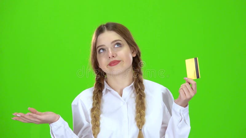 A estudante na blusa branca com um cartão de crédito é triste Tela verde