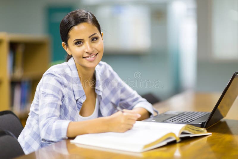 Estudante universitário que estuda a biblioteca imagens de stock Estudante universitário que estuda a biblioteca imagens de stock