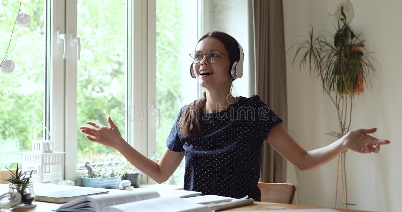 Estudante usa fones de ouvido modernos sem fio relaxando cantando música favorita