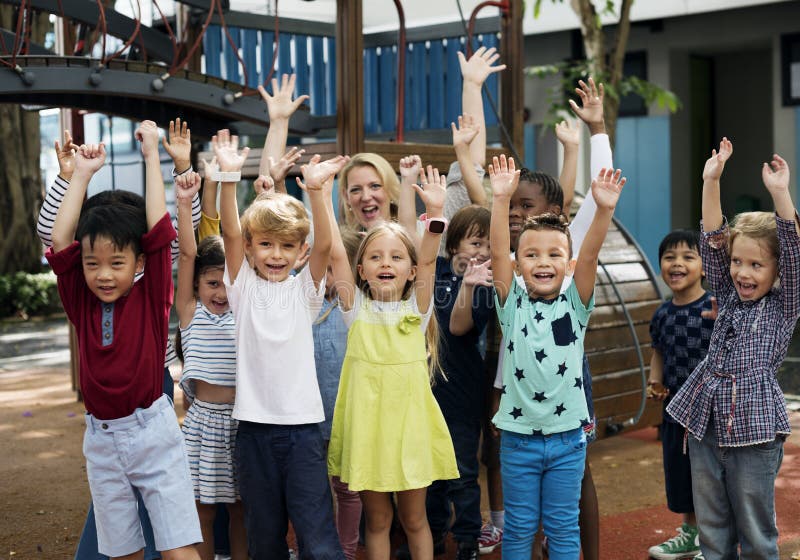 Diverse kindergarten students with arms raised. Diverse kindergarten students with arms raised
