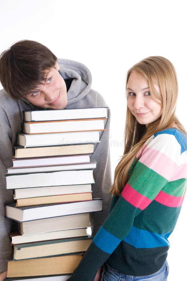 Estudantes novos dos pares com uma pilha dos livros isolados fotografia de stock royalty free Estudantes novos dos pares com uma pilha dos livros isolados fotografia de stock royalty free