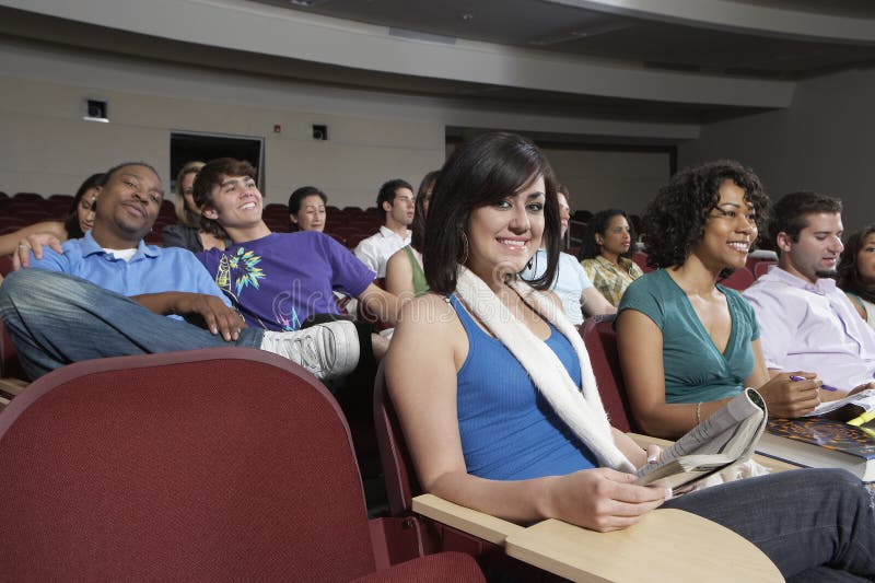 Estudantes que sentam-se junto na sala de aula imagens de stock Estudantes que sentam-se junto na sala de aula imagens de stock