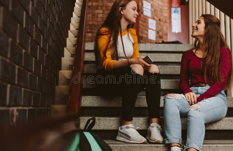 Estudantes universitário que conversam durante a ruptura no terreno imagem de stock royalty free Estudantes universitário que conversam durante a ruptura no terreno imagem de stock royalty free