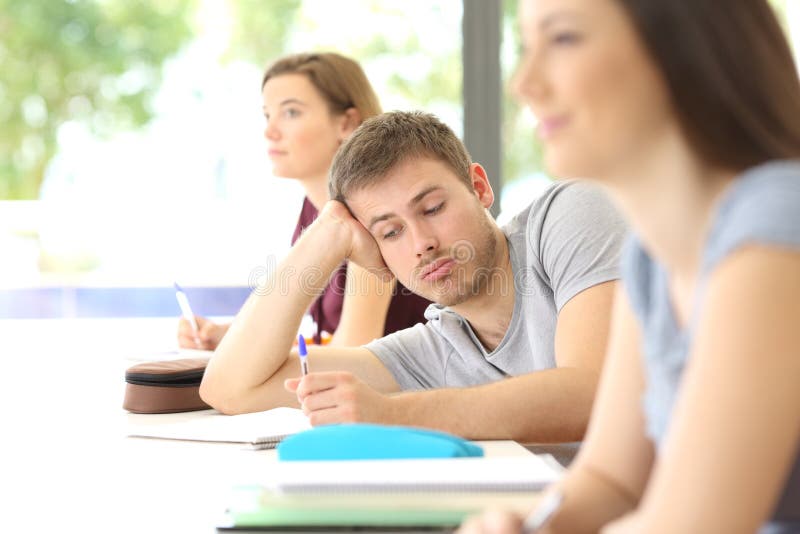Estudiante aburrido distraído durante una clase en la sala de clase imágenes de archivo libres de regalías