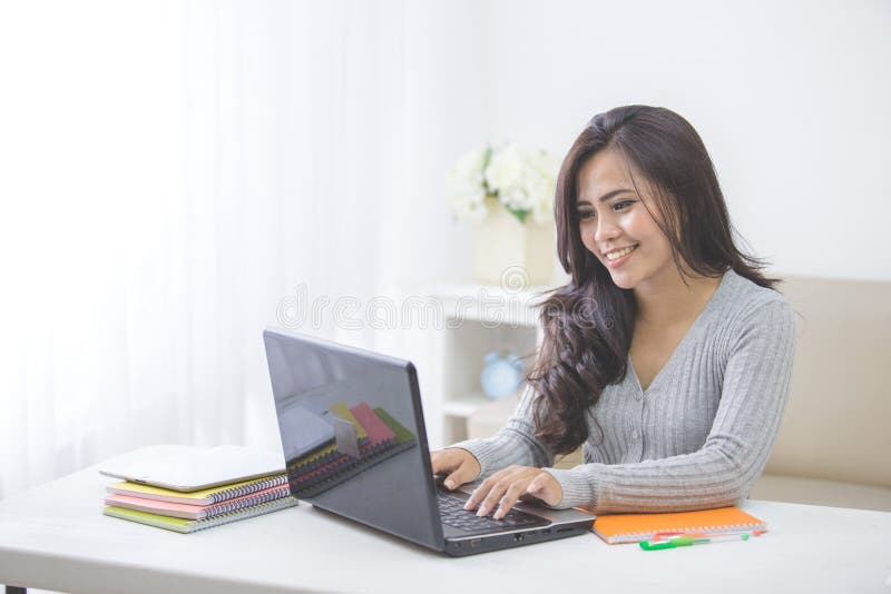 estudiante asiático en casa que estudia usando el ordenador portátil foto de archivo libre de regalías estudiante asiático en casa que estudia usando el ordenador portátil foto de archivo libre de regalías