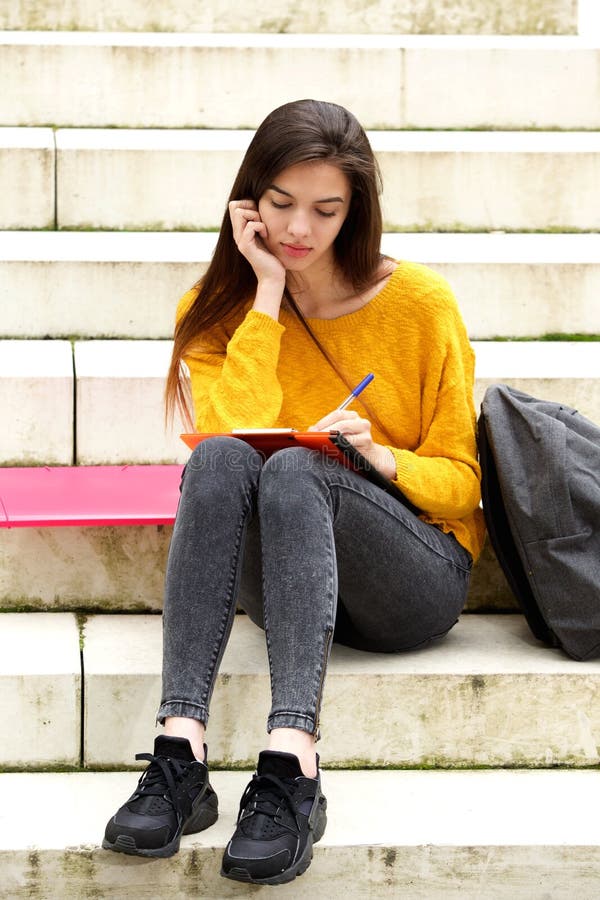 Estudiante atractivo que se sienta en el pensamiento de los pasos foto de archivo Estudiante atractivo que se sienta en el pensamiento de los pasos foto de archivo