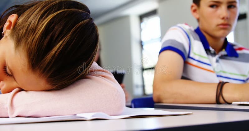 Estudiante cansado que duerme en sala de clase