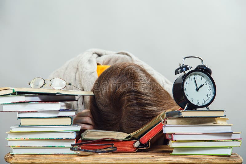 Estudiante con los libros de lectura de los vidrios foto de archivo libre de regalías Estudiante con los libros de lectura de los vidrios foto de archivo libre de regalías
