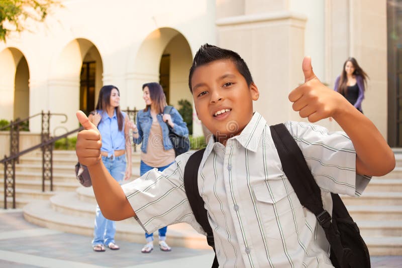 Estudiante hispánico masculino joven Boy con los pulgares para arriba en campus fotografía de archivo libre de regalías Estudiante hispánico masculino joven Boy con los pulgares para arriba en campus fotografía de archivo libre de regalías