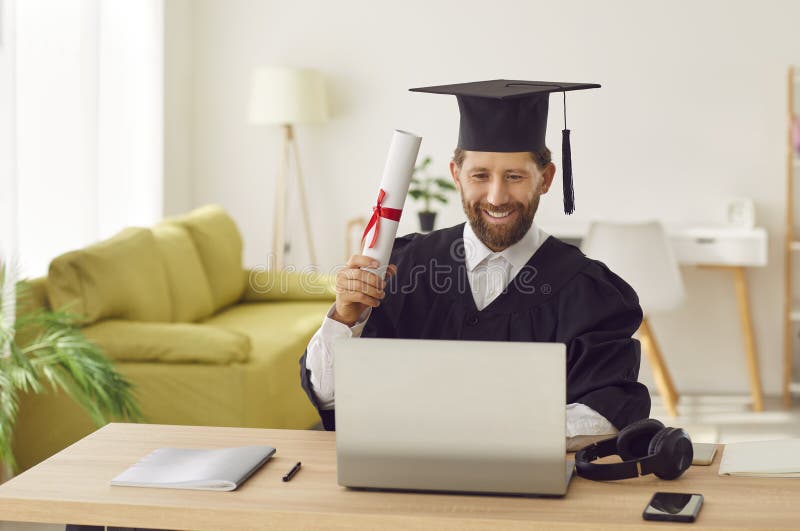 Estudiante masculino completa el título en línea obtiene diploma y asiste a la ceremonia de graduación en laptop fotos de archivo libres de regalías