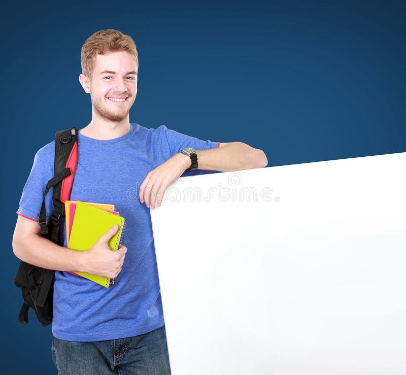 Estudiante masculino joven que lleva a cabo al tablero en blanco blanco fotos de archivo libres de regalías Estudiante masculino joven que lleva a cabo al tablero en blanco blanco fotos de archivo libres de regalías