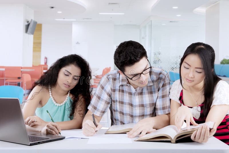 Estudiante masculino que estudia con sus amigos fotos de archivo Estudiante masculino que estudia con sus amigos fotos de archivo