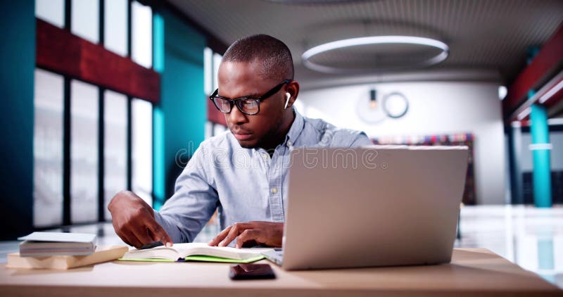 Estudiante masculino que estudia en computación imagenes de archivo