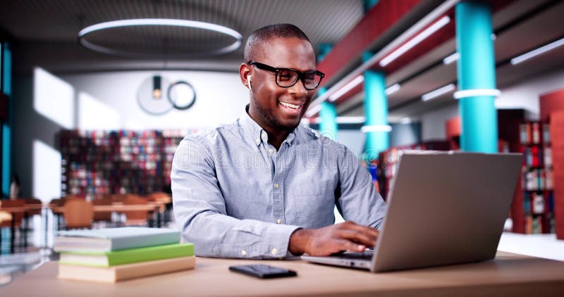 Estudiante masculino que estudia en computación foto de archivo