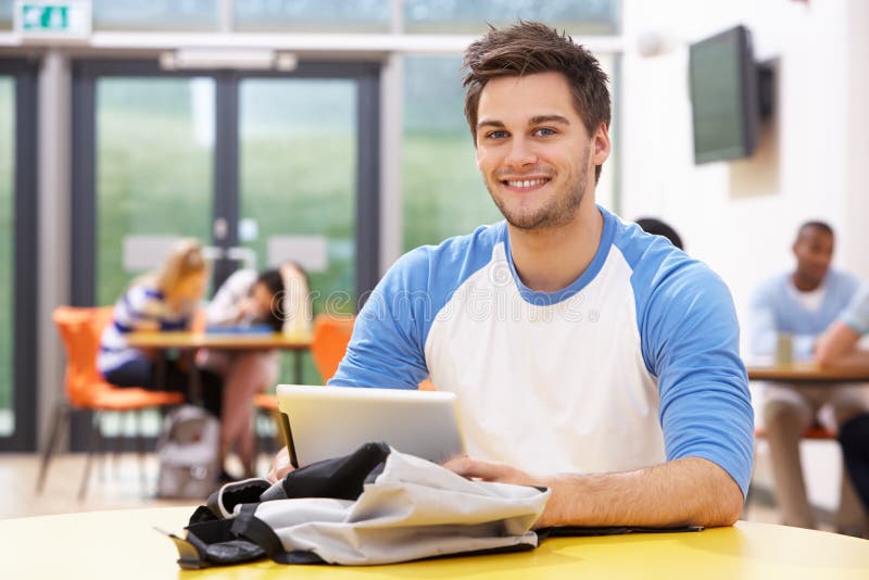 Estudiante masculino Studying In Classroom con la tableta de Digitaces imágenes de archivo libres de regalías