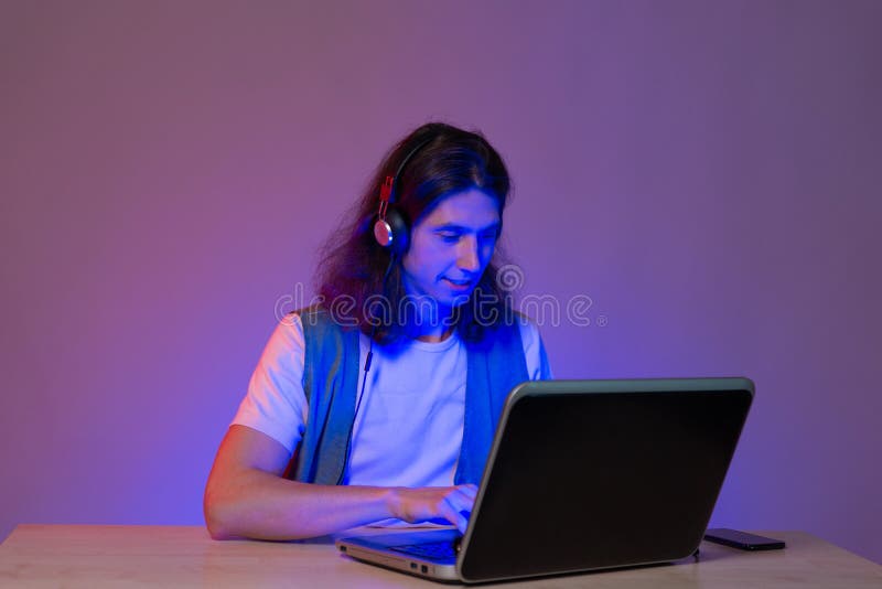 Estudiante o jugador en un portátil retrato en teñido de neón. foto de archivo libre de regalías