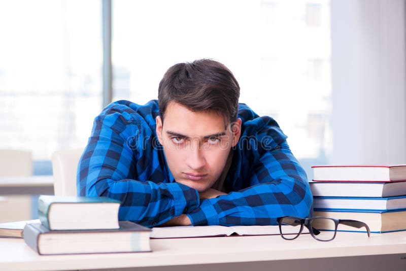 Estudiante que estudia en la biblioteca vacía con el libro que se prepara para ex imagen de archivo