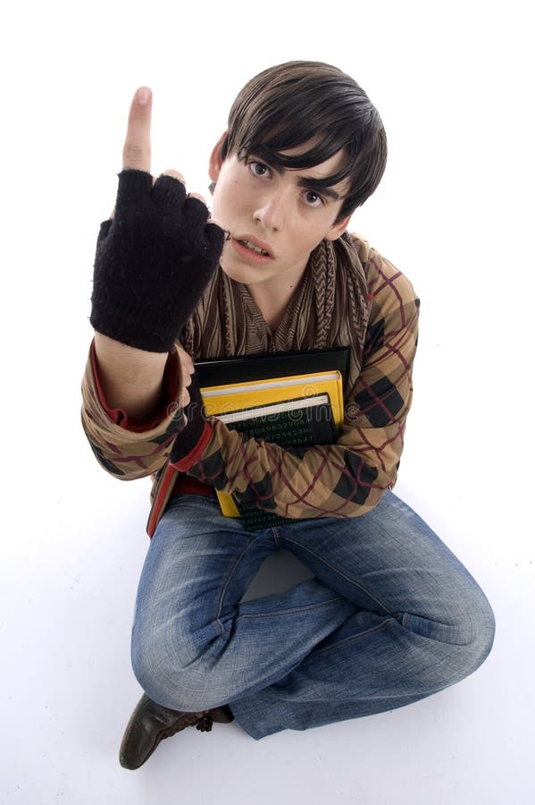 Estudiante que se sienta que muestra el dedo imagen de archivo Estudiante que se sienta que muestra el dedo imagen de archivo