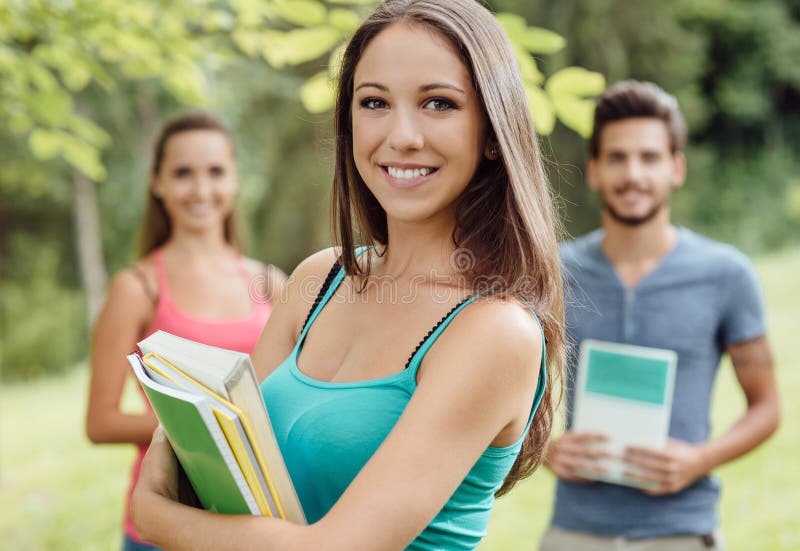 Estudiante sonriente que presenta con los cuadernos fotos de archivo Estudiante sonriente que presenta con los cuadernos fotos de archivo