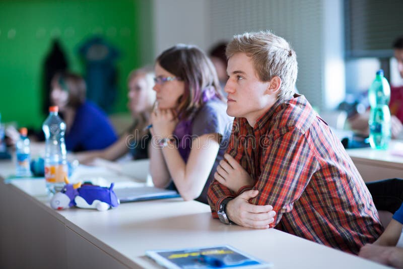 Estudiante universitario que se sienta en una sala de clase fotografía de archivo libre de regalías Estudiante universitario que se sienta en una sala de clase fotografía de archivo libre de regalías