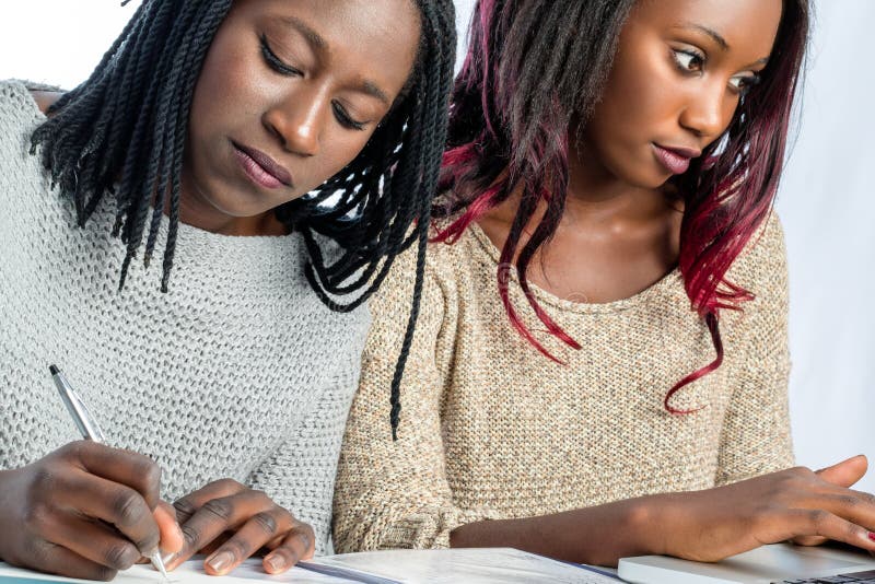 Estudiantes adolescentes africanos que trabajan junto en el escritorio fotos de archivo libres de regalías Estudiantes adolescentes africanos que trabajan junto en el escritorio fotos de archivo libres de regalías