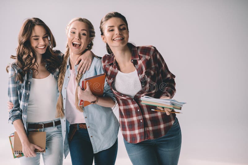 Estudiantes de mujeres felices jovenes con los libros de texto en manos imágenes de archivo libres de regalías Estudiantes de mujeres felices jovenes con los libros de texto en manos imágenes de archivo libres de regalías
