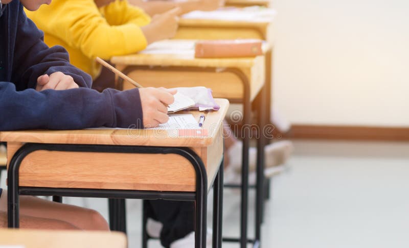 Estudiantes que escriben el examen de la prueba en el papel para las admisiones en alto schoo foto de archivo Estudiantes que escriben el examen de la prueba en el papel para las admisiones en alto schoo foto de archivo