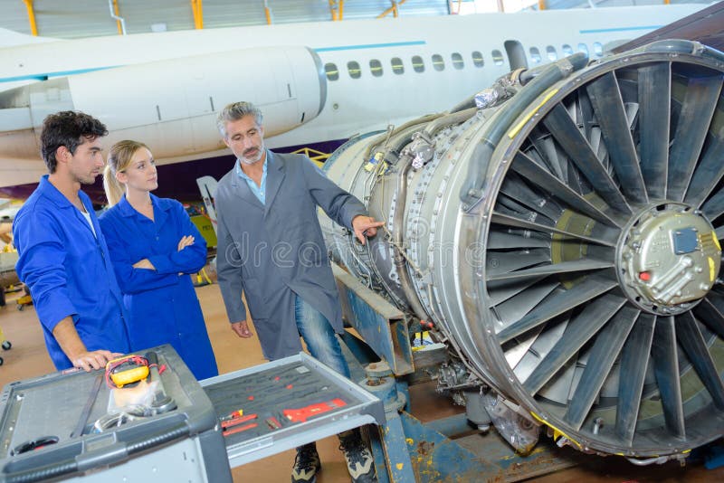 Estudiantes que miran la turbina de los aviones fotos de archivo Estudiantes que miran la turbina de los aviones fotos de archivo