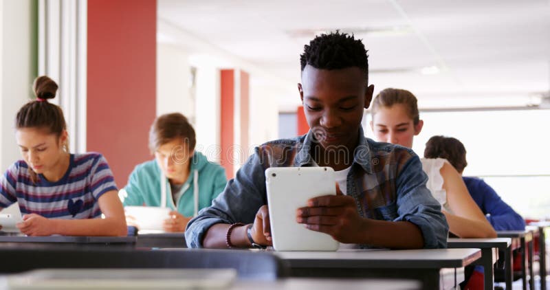 Estudiantes que usan las tabletas digitales en sala de clase