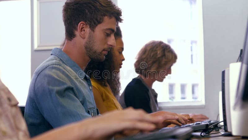 Estudiantes que usan los ordenadores en la sala de ordenadores