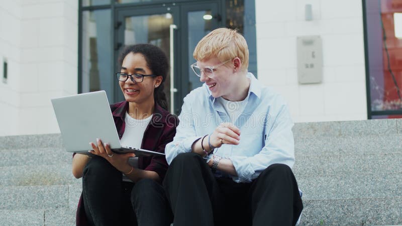 Estudiantes trabajando en laptop y sonriendo afuera metrajes