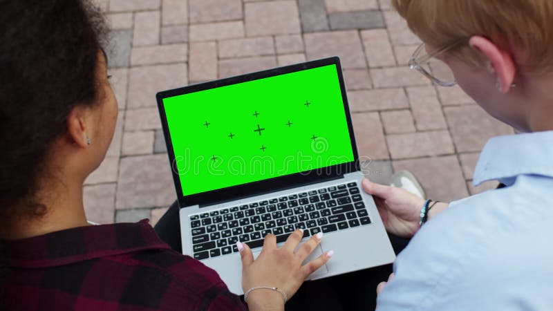 Estudiantes trabajando en un portátil con pantalla verde almacen de metraje de vídeo