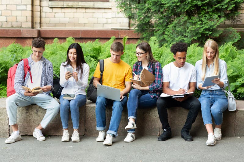 Estudiantes universitarios que estudian en campus universitario con los libros foto de archivo Estudiantes universitarios que estudian en campus universitario con los libros foto de archivo