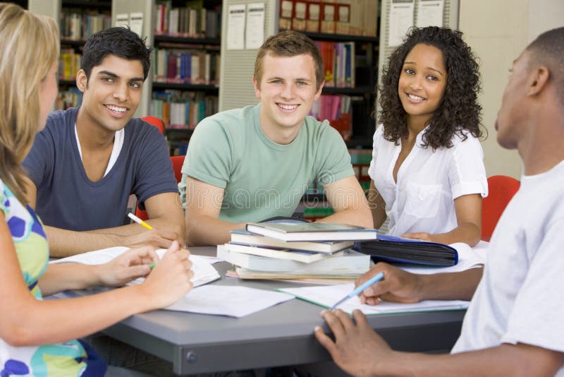 Estudiantes universitarios que estudian junto en una biblioteca imagenes de archivo