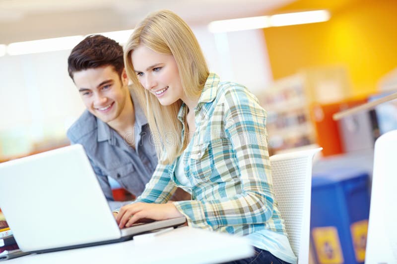 Estudiantes universitarios y portátiles para bibliotecas de investigación y educación superior con estudios de proyectos y trabajo foto de archivo libre de regalías