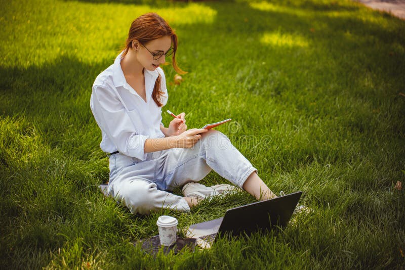 Estudios de chicas hermosas y trabaja con un blogger portátil en casa educación a distancia al aire libre fotos de archivo libres de regalías