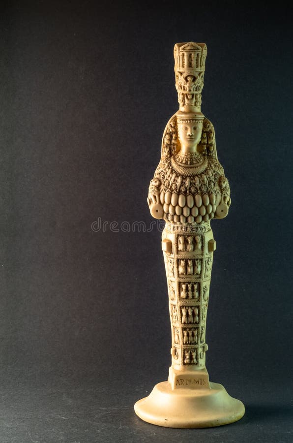 Photograph of a statuette of the Goddess Artemis of Ephesus on a smooth grey background. Photograph of a statuette of the Goddess Artemis of Ephesus on a smooth grey background