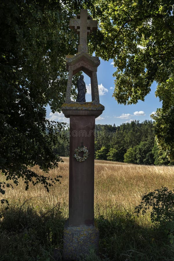 Estátua de pedra da tortura divina entre as árvores em um trajeto do campo fotos de stock Estátua de pedra da tortura divina entre as árvores em um trajeto do campo fotos de stock