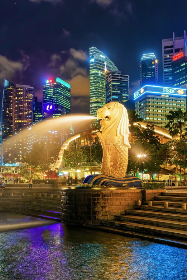 A estátua dos arranha-céus e do Merlion em Merlion estaciona no crepúsculo foto de stock