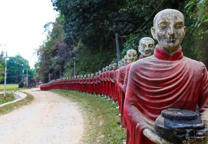 Statues of monks in robes collecting alms near the Myanmar monastery near the cave this bat. Statues of monks in robes collecting alms near the Myanmar monastery near the cave this bat