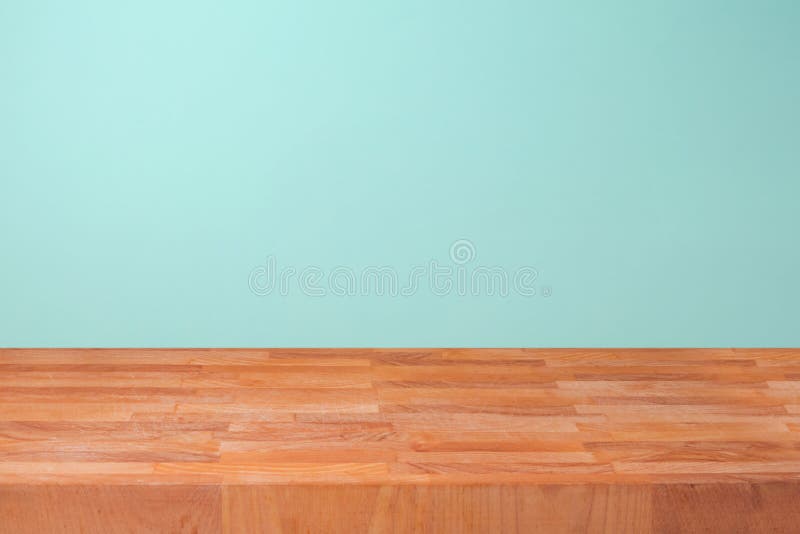 Esvazie o contador de cozinha de madeira sobre o fundo da parede da hortelã para a montagem do produto