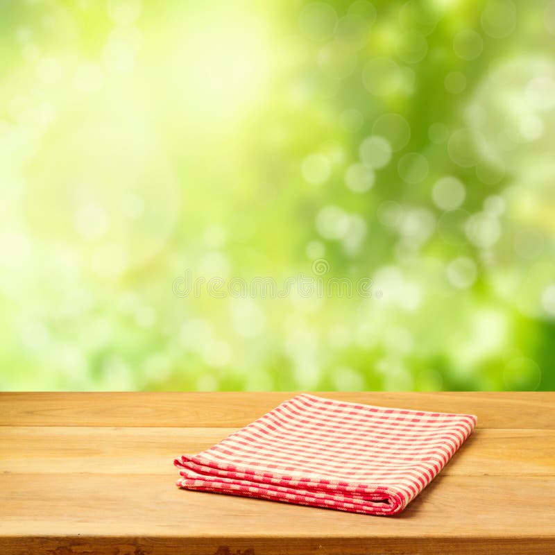 Esvazie a tabela de madeira com toalha de mesa sobre o fundo do bokeh do jardim imagens de stock royalty free Esvazie a tabela de madeira com toalha de mesa sobre o fundo do bokeh do jardim imagens de stock royalty free
