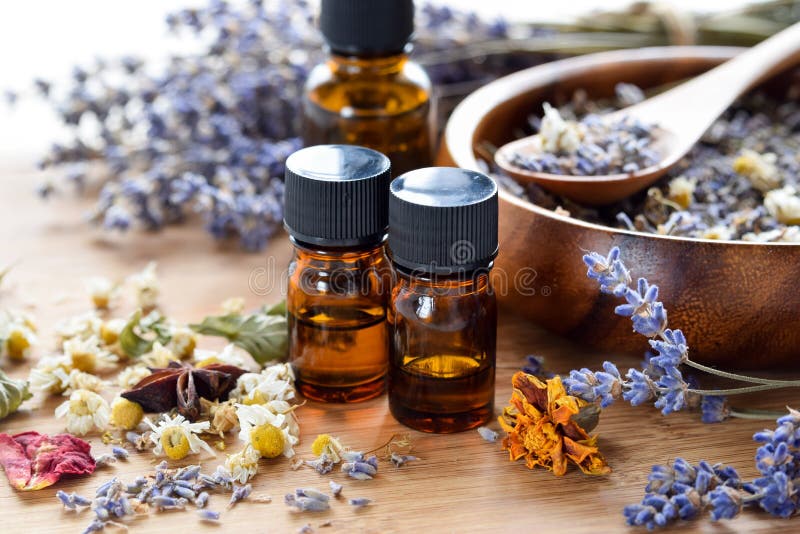 Essential oils with dried herbal flowers on wooden table. Essential oils with dried herbal flowers on wooden table