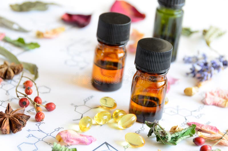 Essential oils with dried herbs and supplement on science sheet. Essential oils with dried herbs and supplement on science sheet