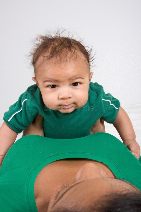 Ethnic mother playing with her baby boy son on bed royalty free stock photography