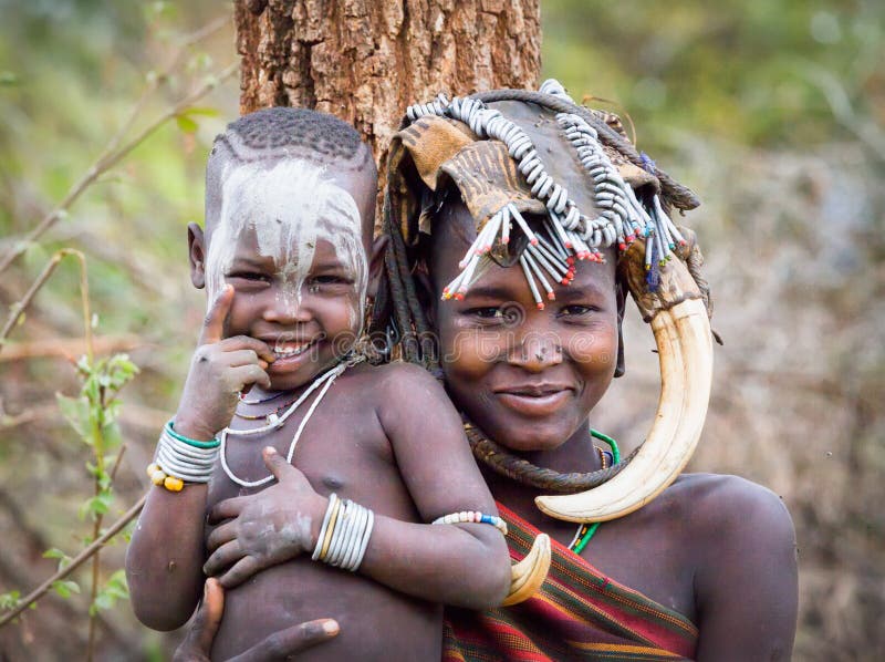 Ethiopia, Omo valley, Cute baby with mother. Mursi tribe. Ethiopia, Omo valley, Cute baby with mother. Mursi tribe