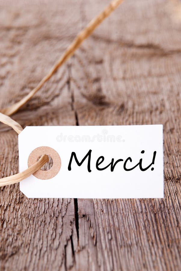 The French Word Merci which means Thanks on a Wooden Board. The French Word Merci which means Thanks on a Wooden Board
