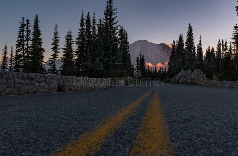 Ett foto för låg vinkel av vägen som upp till leder Mount Rainier på solnedgången, Washington, USA arkivbild Ett foto för låg vinkel av vägen som upp till leder Mount Rainier på solnedgången, Washington, USA arkivbild