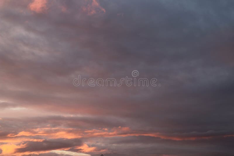 Ett fragment av himlen i guld- lilor och grå färger tonar med moln på solnedgången fotografering för bildbyråer Ett fragment av himlen i guld- lilor och grå färger tonar med moln på solnedgången fotografering för bildbyråer